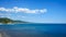 Expanse of blue sea with a high shore and blue sky