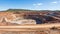 Expansive aerial view of a colossal quarry mining operation dedicated to the extraction of iron ore