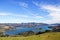 Expansive body of water set against a backdrop of rolling hills in New Zealand.