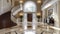 An Expansive Entry Foyer Boasting Elegant Marble Flooring, Arched Windows and Sidelights, and a Grand Staircase with a Lustrous