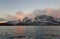 Expansive fjord in the Lofoten Islands surrounded with snowy mountains and a colorful winter sunset. Norway.