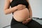 Expectant mother is sitting on a massage table