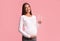 Expectant Woman Standing Holding Glass Of Water Smiling, Studio Shot