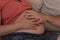 Expecting couple touch hands on pregnant tummy