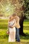 Expecting mom and dad kissing under flowering tree