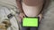 expecting pregnant woman with large belly using tablet with chromakey on bed