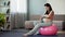 Expecting woman massaging pregnant belly, taking care of baby and body fitness