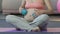 Expecting woman rolling massage balls over stomach, relaxing therapy, body care