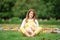 Expecting young female mother posing in park holding plush toy