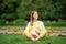 Expecting young female mother posing in park holding plush toy