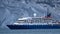 Expedition cruise ship in front of snow covered mountain in Antarctica