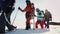 The expedition of men and women goes one after another in the high snow, the girls help themselves with ski poles. in