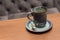 Expensive beautiful blue ceramic coffee mug on wooden table in coffee shop. A glass of black tea on a wooden surface against a