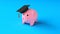 Expensive education. Piggy bank in a cap of a graduate on a blue background. Savings for education. 3d render