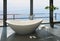 Expensive luxury bathtub against panoramic window with seascape view