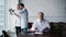 Experienced adult doctor sits at his desk and studies his patients` documents