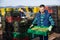 Experienced adult farmer working on vegetable plantation, stacking plastic boxes with freshly harvested artichokes