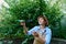 Experienced agriculturist examines sprouted seedlings cultivated in agricultural cassette before planting in open ground