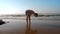 Experienced athlete stands in wet sand reflecting silhouette