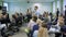 An experienced business coach, speaking at a conference in front of a large number of managers. Man shows the image from