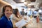 An experienced business woman in the company of colleagues posing for a photo at coffee break at the bar. Business, people, bar