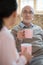 Experienced caregiver and senior man having tea time