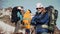 An experienced climber with a gray beard and glasses standing with arms crossed on his chest and enjoying the view