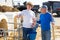 Experienced dairy farm owner teaching young worker