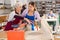 Experienced elderly woman potter teaches young student how to work on craft machine clay press roller