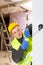 Experienced electrician laying electric wires in building under construction