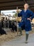 Experienced female farmer standing with pitchfork in livestock farm