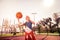 Experienced long-haired girl actively throwing orange ball