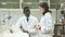 Experienced male and female scientists standing in interior of laboratory