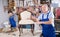 Experienced male restorer showing restored vintage chair in workshop