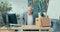 Experienced man with gray hair dressed in shirt stands in front of desk in corporate office holding box of packaged