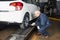 Experienced mechanic checks tire pressure on the car