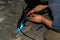 An experienced person performs work with a welding machine, fixing metal parts, removing blue smoke and yellow sparks and