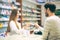 Experienced pharmacist counseling male customer in pharmacy