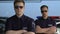 Experienced policemen in sunglasses crossing hands and looking into camera