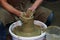 Experienced potter makes a large vase on a potter`s wheel. clay product. hands of a potter. reportage shooting