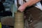 Experienced potter makes a large vase on a potter`s wheel. clay product. hands of a potter. reportage shooting