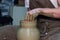 Experienced potter makes a large vase on a potter`s wheel. clay product. hands of a potter. reportage shooting
