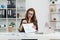 Experienced successful business lady in stylish clothes and glasses talking with her business partner by video call and