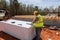 An experienced supervisor in a hard hat safety vest checks the house project plan on the construction site by monitoring