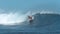 Experienced surfer rides a big crystal clear barrel wave on popular surf spot.