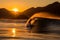 Experienced Surfer Riding Waves during Stunning Golden Sunset on a Picturesque Ocean Beach