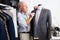 Experienced tailor tries on a new jacket on a mannequin in sewing atelier