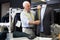 Experienced tailor tries on a new jacket on a mannequin in workshop