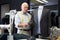Experienced tailor tries on a new jacket on a mannequin in workshop