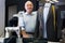 Experienced tailor tries on a new jacket on a mannequin in workshop